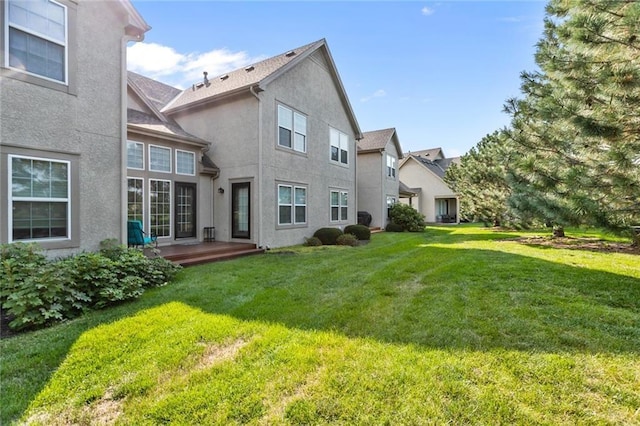 2118 NE 107th Ter, Kansas City, MO 64155 - back of house with stucco siding and a lawn