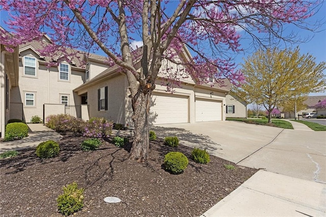 2118 NE 107th Ter, Kansas City, MO 64155 - view of side of property featuring concrete driveway, stucco siding, and an attached garage