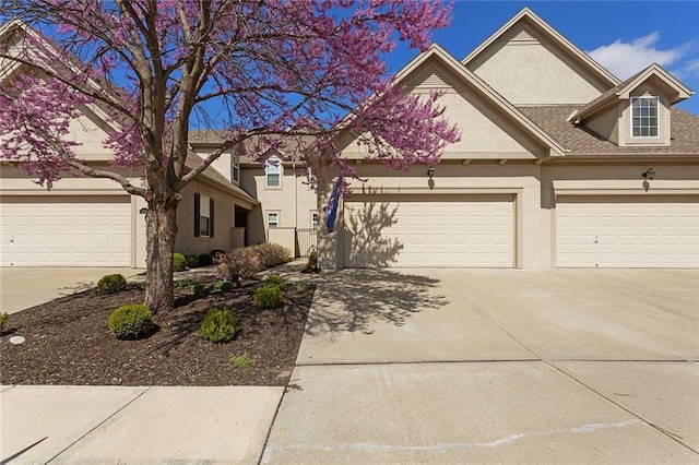 2118 NE 107th Ter, Kansas City, MO 64155 - view of front of home with a garage, driveway, and stucco siding