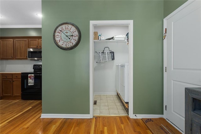 2118 NE 107th Ter, Kansas City, MO 64155 - interior space featuring washer / clothes dryer, light wood finished floors, baseboards, and crown molding