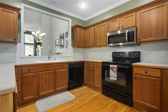 2118 NE 107th Ter, Kansas City, MO 64155 - kitchen with a sink, light countertops, a chandelier, brown cabinetry, and black appliances