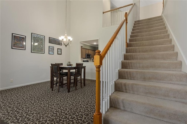 2118 NE 107th Ter, Kansas City, MO 64155 - staircase featuring a chandelier, carpet, a high ceiling, and baseboards