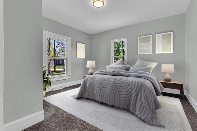bedroom with visible vents, baseboards, multiple windows, and carpet flooring
