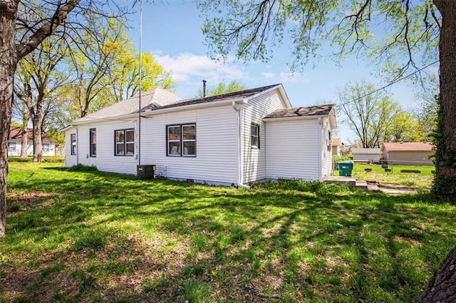 view of side of property with a yard and cooling unit
