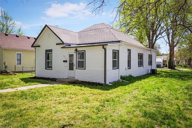 view of front of property with a shingled roof and a front yard