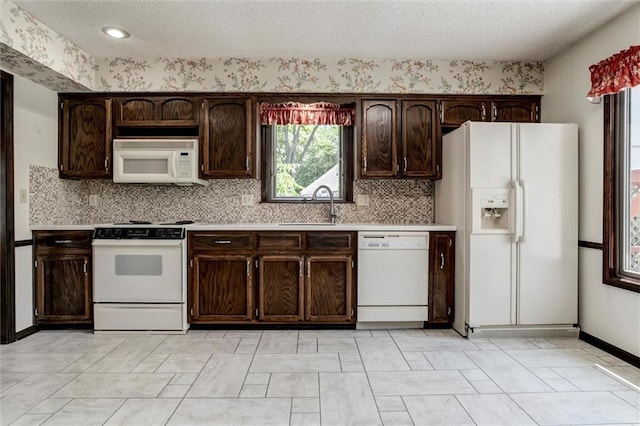 12253 W 104th St, Lenexa, KS 66215 - kitchen featuring white appliances, a sink, light countertops, dark brown cabinetry, and decorative backsplash