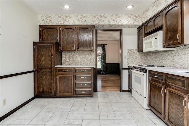 12253 W 104th St, Lenexa, KS 66215 - kitchen with white appliances, dark brown cabinetry, light countertops, tasteful backsplash, and recessed lighting