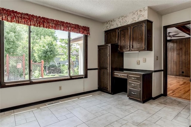 12253 W 104th St, Lenexa, KS 66215 - kitchen with plenty of natural light, dark brown cabinetry, and a textured ceiling