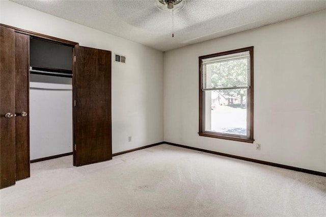 12253 W 104th St, Lenexa, KS 66215 - unfurnished bedroom featuring light carpet, a textured ceiling, baseboards, and a closet