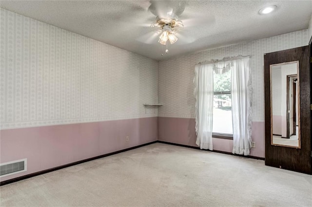 12253 W 104th St, Lenexa, KS 66215 - carpeted empty room with wallpapered walls, a ceiling fan, baseboards, and a textured ceiling