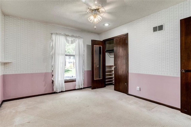 12253 W 104th St, Lenexa, KS 66215 - unfurnished bedroom with wallpapered walls, carpet flooring, baseboards, a textured ceiling, and a ceiling fan