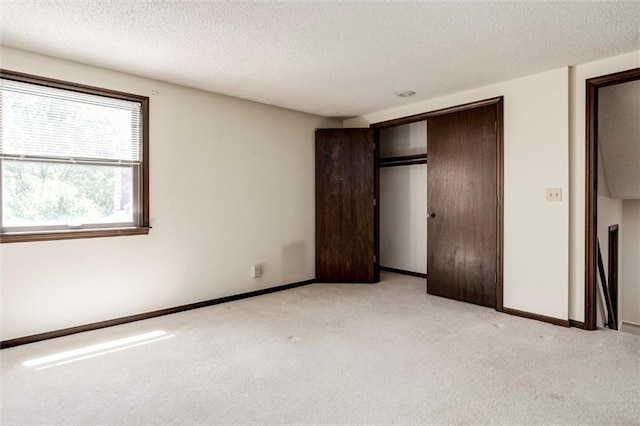 12253 W 104th St, Lenexa, KS 66215 - unfurnished bedroom with light carpet, a textured ceiling, a closet, and baseboards