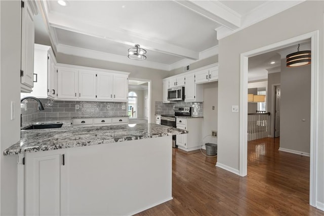 12314 England St, Overland Park, KS 66213 - kitchen with a peninsula, white cabinets, appliances with stainless steel finishes, a sink, and beam ceiling