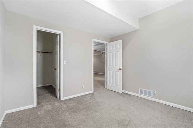 12314 England St, Overland Park, KS 66213 - unfurnished bedroom with visible vents, baseboards, a walk in closet, and carpet flooring