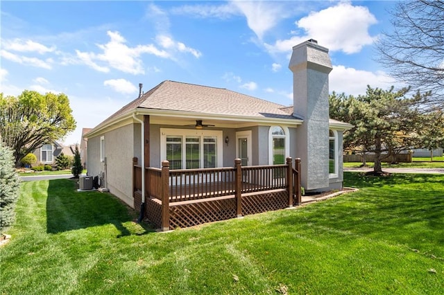 12314 England St, Overland Park, KS 66213 - back of property featuring central AC unit, a yard, a ceiling fan, a chimney, and stucco siding