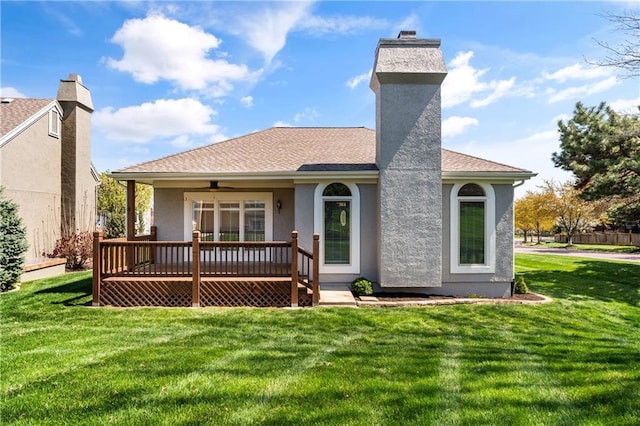 12314 England St, Overland Park, KS 66213 - back of house featuring stucco siding, a chimney, a wooden deck, a yard, and a shingled roof