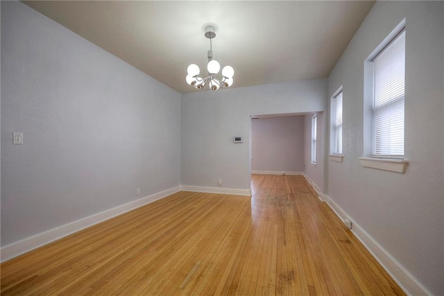 220-222 W Armour Blvd, Kansas City, MO 64111 - unfurnished room with an inviting chandelier, light wood finished floors, and baseboards