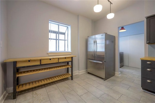 220-222 W Armour Blvd, Kansas City, MO 64111 - kitchen featuring decorative light fixtures, baseboards, freestanding refrigerator, washer / dryer, and light tile patterned flooring
