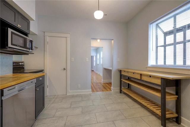 220-222 W Armour Blvd, Kansas City, MO 64111 - kitchen with tasteful backsplash, light tile patterned floors, light countertops, baseboards, and stainless steel appliances