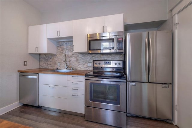 220-222 W Armour Blvd, Kansas City, MO 64111 - kitchen featuring decorative backsplash, appliances with stainless steel finishes, a sink, white cabinetry, and dark wood-type flooring