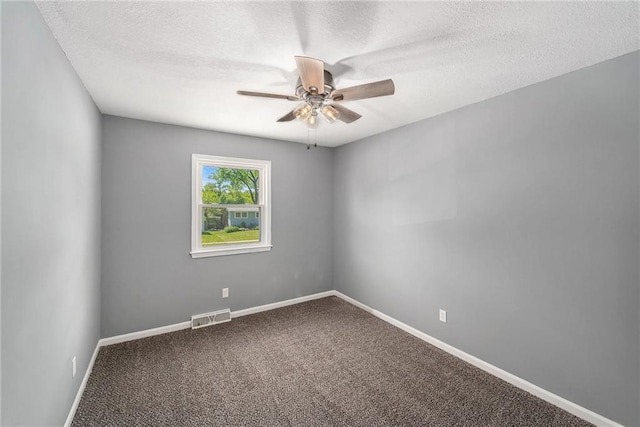 carpeted spare room featuring ceiling fan, baseboards, and a textured ceiling