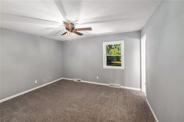 spare room featuring a ceiling fan, a textured ceiling, dark carpet, and baseboards