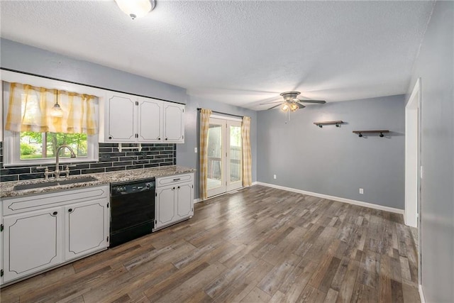 kitchen with dishwasher, a sink, ceiling fan, white cabinets, and backsplash