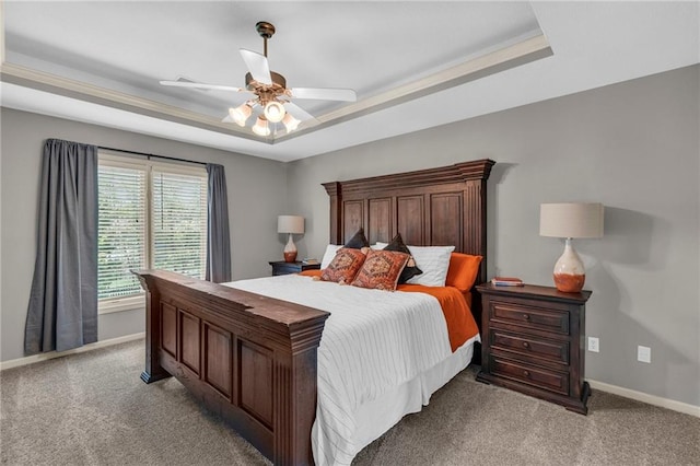 bedroom with baseboards, ceiling fan, a tray ceiling, and light colored carpet