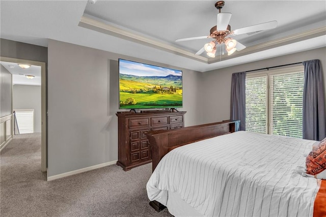 carpeted bedroom with baseboards, a ceiling fan, and a tray ceiling