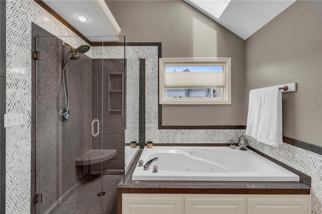 bathroom featuring a whirlpool tub, a stall shower, and lofted ceiling with skylight
