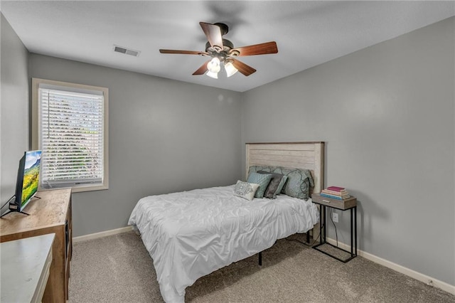 carpeted bedroom featuring baseboards, ceiling fan, and visible vents