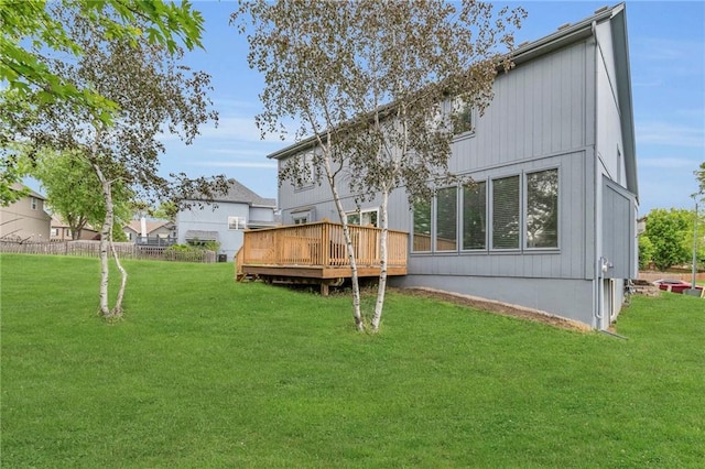 back of house featuring a lawn, fence, and a wooden deck