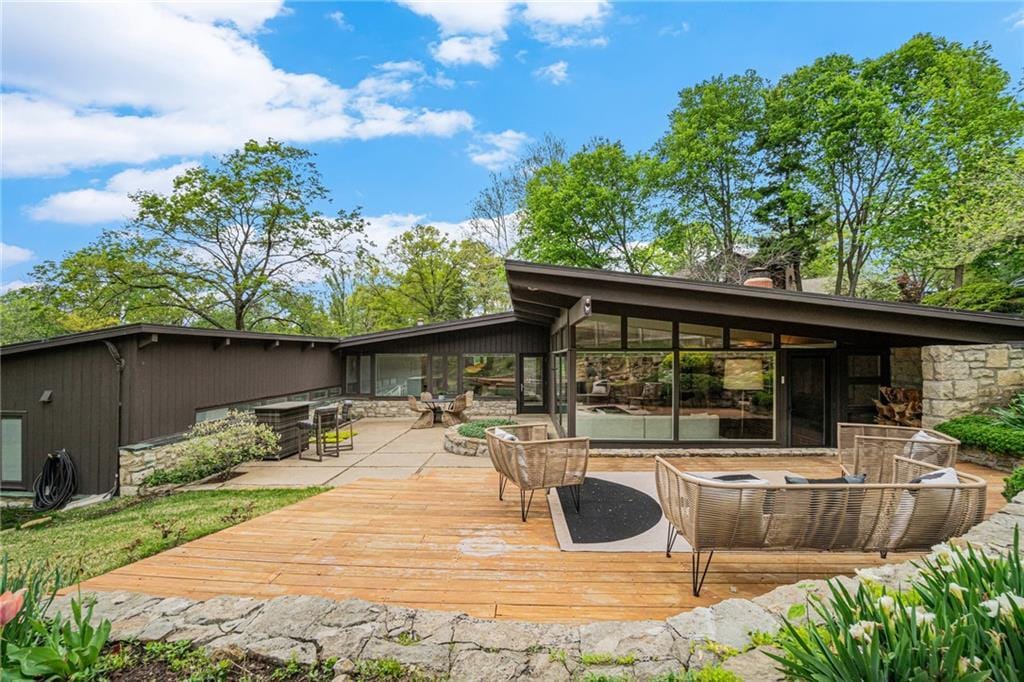 2400 W 86th Ter, Leawood, KS 66206 - back of property featuring a deck, stone siding, and a chimney