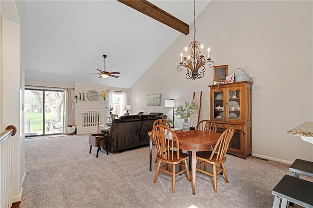 dining space featuring a fireplace, beamed ceiling, ceiling fan with notable chandelier, high vaulted ceiling, and light carpet