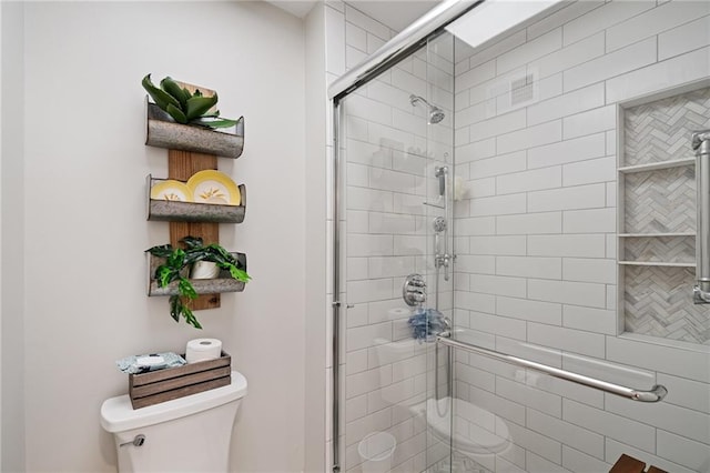 full bath featuring a stall shower and toilet
