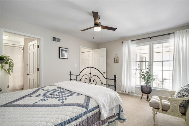 carpeted bedroom with visible vents, baseboards, and a ceiling fan