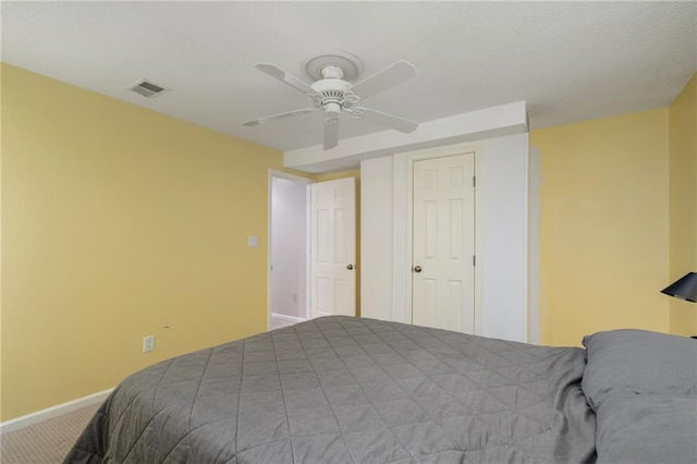 carpeted bedroom featuring ceiling fan, baseboards, and visible vents