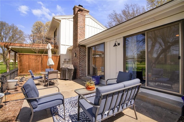 view of patio / terrace featuring grilling area, outdoor dining space, fence, and an outdoor living space