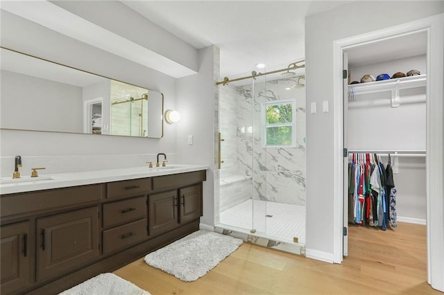 222 Chippewa Ln, Lake Winnebago, MO 64034 - bathroom featuring wood finished floors, a marble finish shower, double vanity, and a walk in closet
