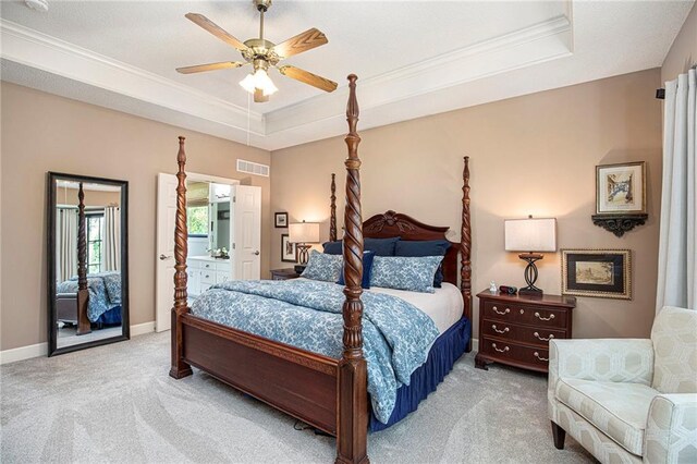 bedroom featuring crown molding, light colored carpet, a raised ceiling, baseboards, and visible vents