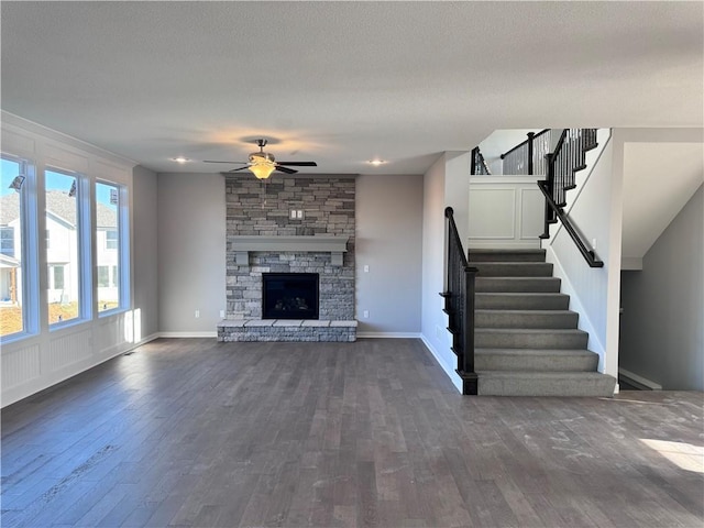 11432 S Langley St, Olathe, KS 66061 - unfurnished living room with ceiling fan, baseboards, dark wood-style floors, and stairs