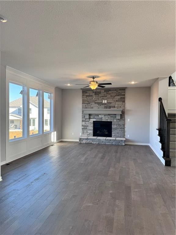 11432 S Langley St, Olathe, KS 66061 - unfurnished living room featuring dark wood-style flooring, baseboards, a ceiling fan, and stairs