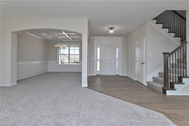 11448 S Langley St, Olathe, KS 66061 - foyer with carpet floors, wainscoting, stairway, a chandelier, and arched walkways