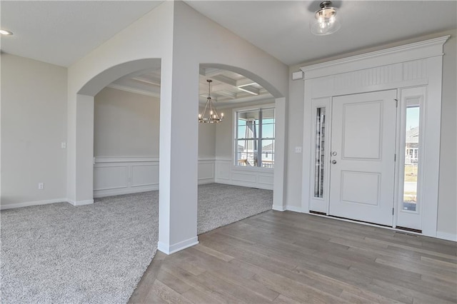 11448 S Langley St, Olathe, KS 66061 - foyer entrance featuring an inviting chandelier, beam ceiling, arched walkways, wood finished floors, and coffered ceiling