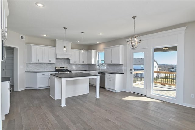 11448 S Langley St, Olathe, KS 66061 - kitchen with stainless steel appliances, white cabinetry, wood finished floors, and tasteful backsplash
