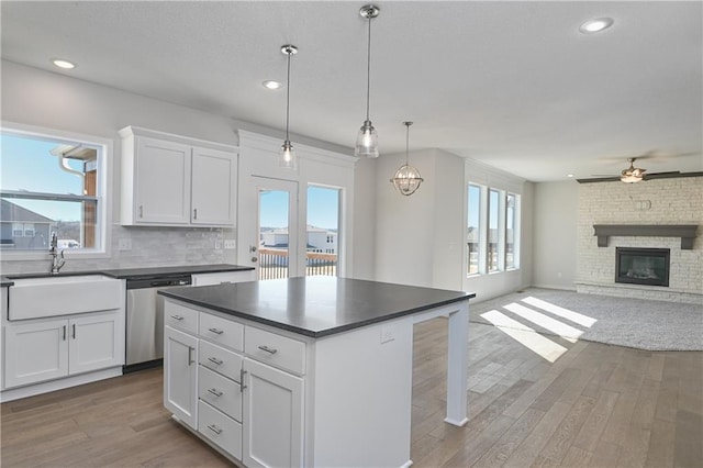 11448 S Langley St, Olathe, KS 66061 - kitchen with dark countertops, ceiling fan, a sink, wood finished floors, and stainless steel dishwasher