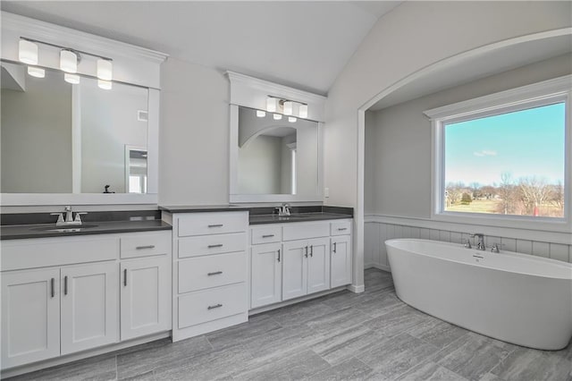 11448 S Langley St, Olathe, KS 66061 - full bath featuring vanity, a wainscoted wall, vaulted ceiling, and a soaking tub
