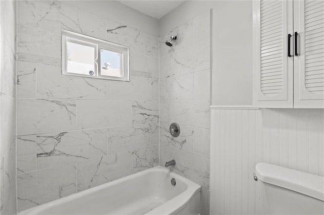 bathroom with shower / tub combination, toilet, and wainscoting