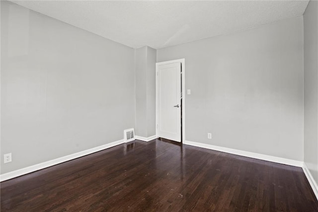 unfurnished room featuring visible vents, baseboards, and wood finished floors