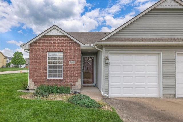 ranch-style home with brick siding, a garage, a front yard, and aphalt driveway